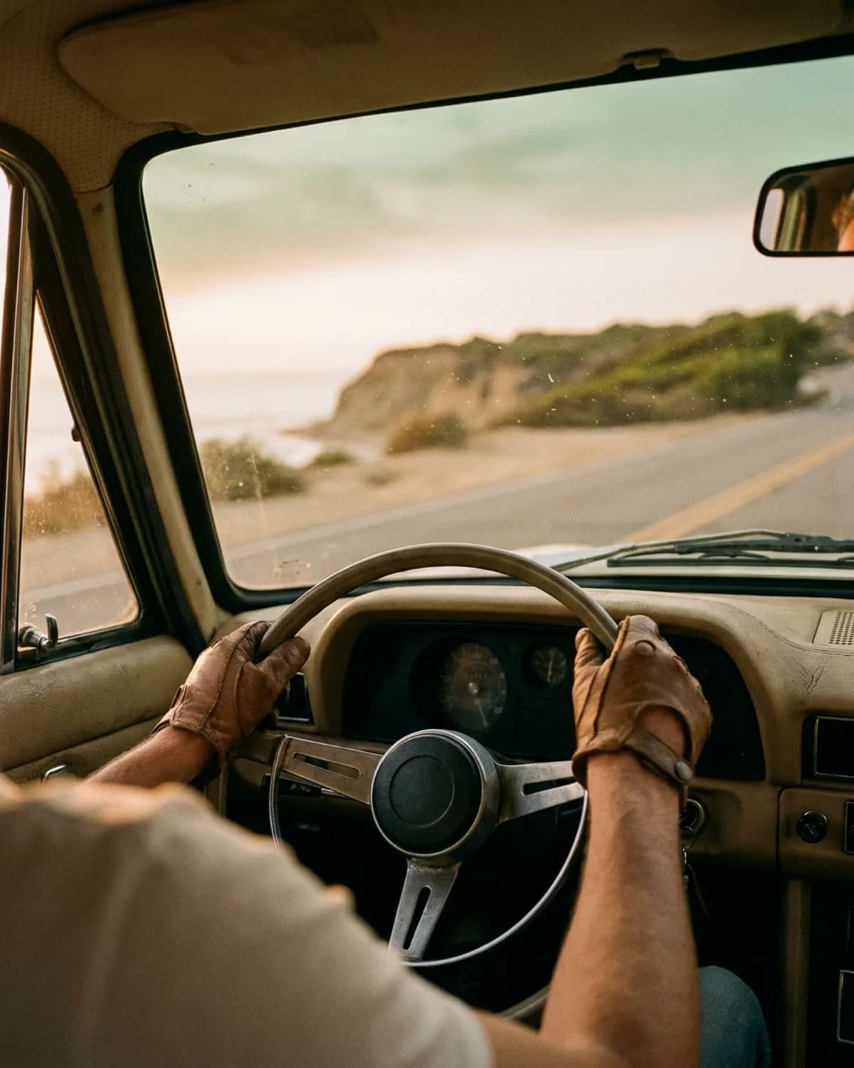 Manos relajadas en el volante, carretera de la Costa Daurada al amanecer.